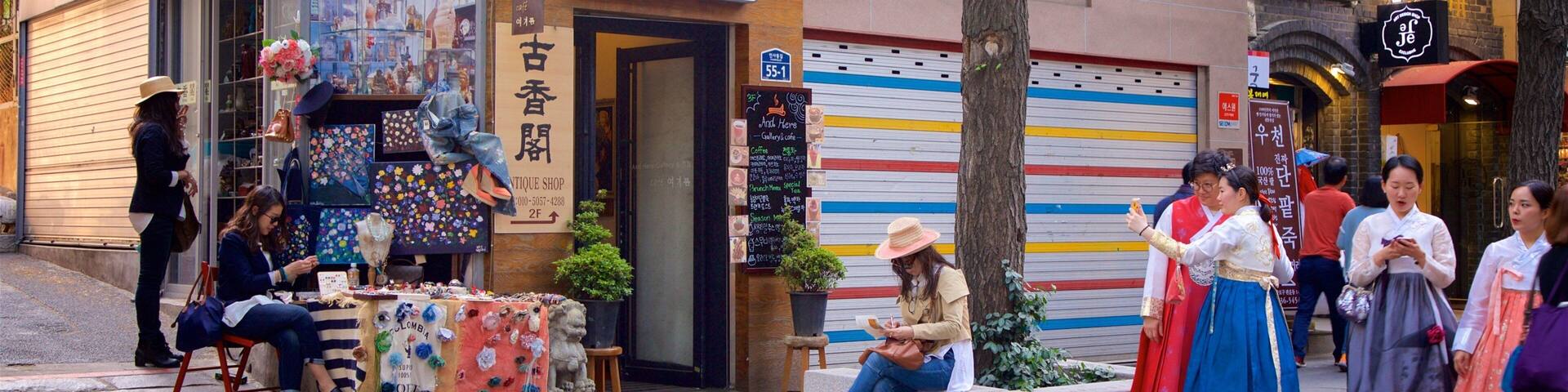 A street with a shop displaying colorful items and a sign for an antique shop.