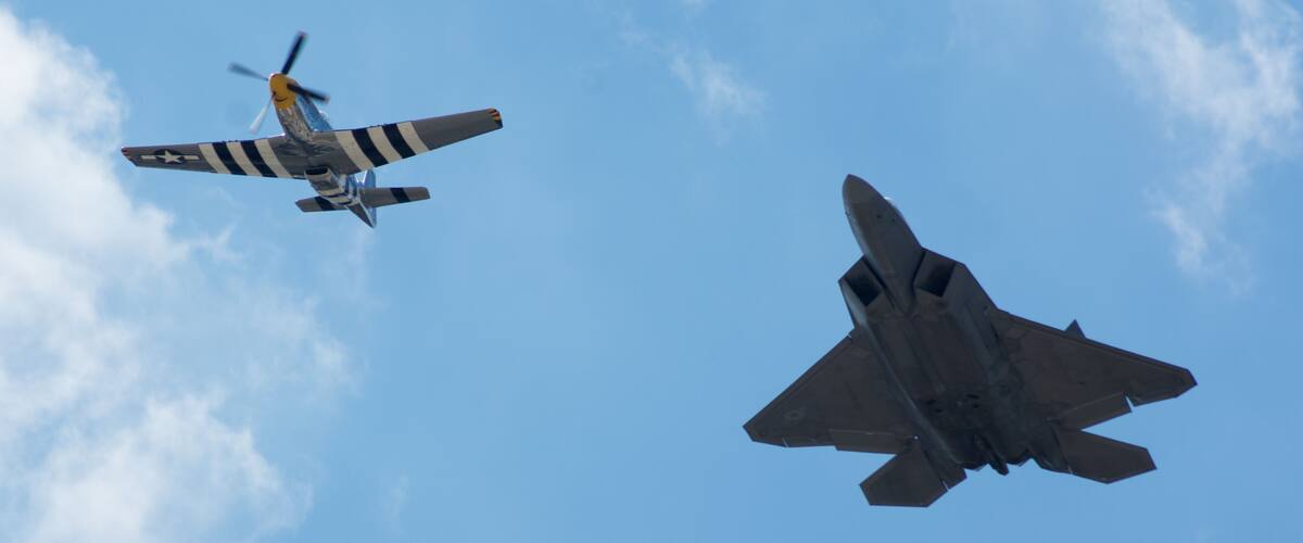 Two military aircraft flying in formation against a clear blue sky.