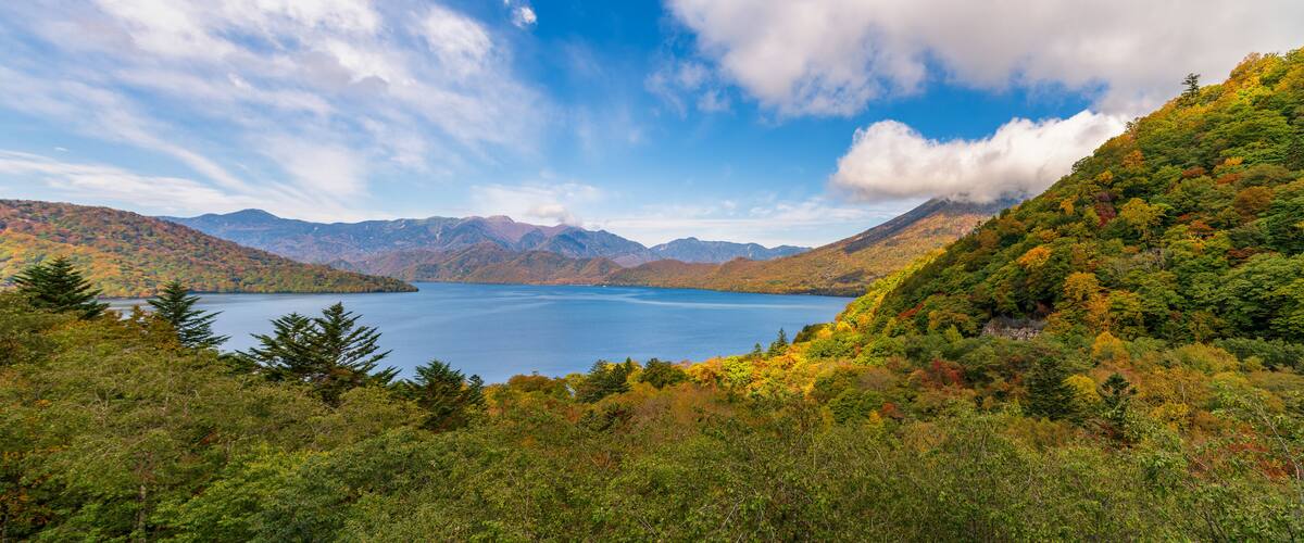 A lake surrounded by mountains with autumn foliage.