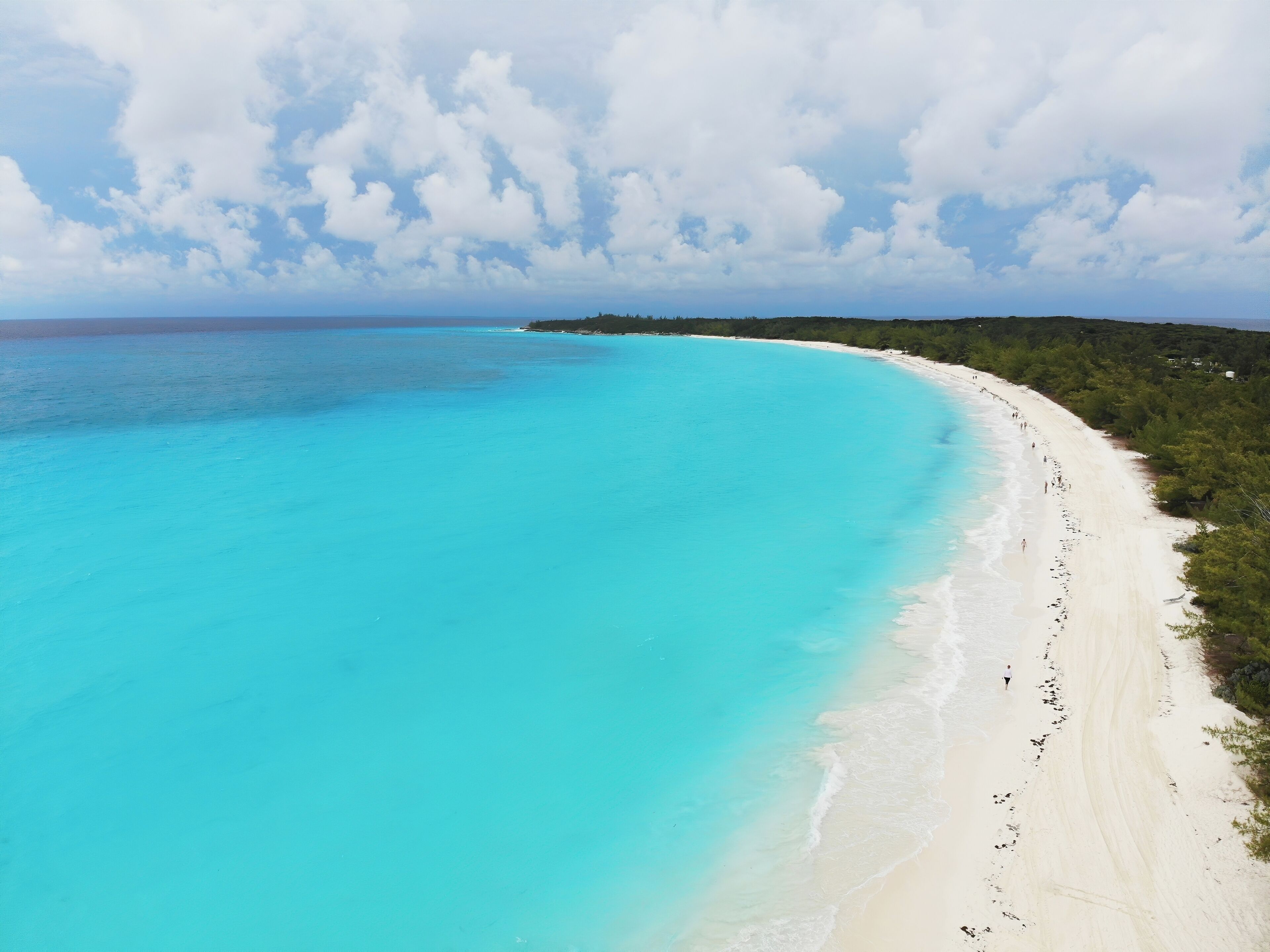 A turquoise beach with white sand and a clear blue ocean.