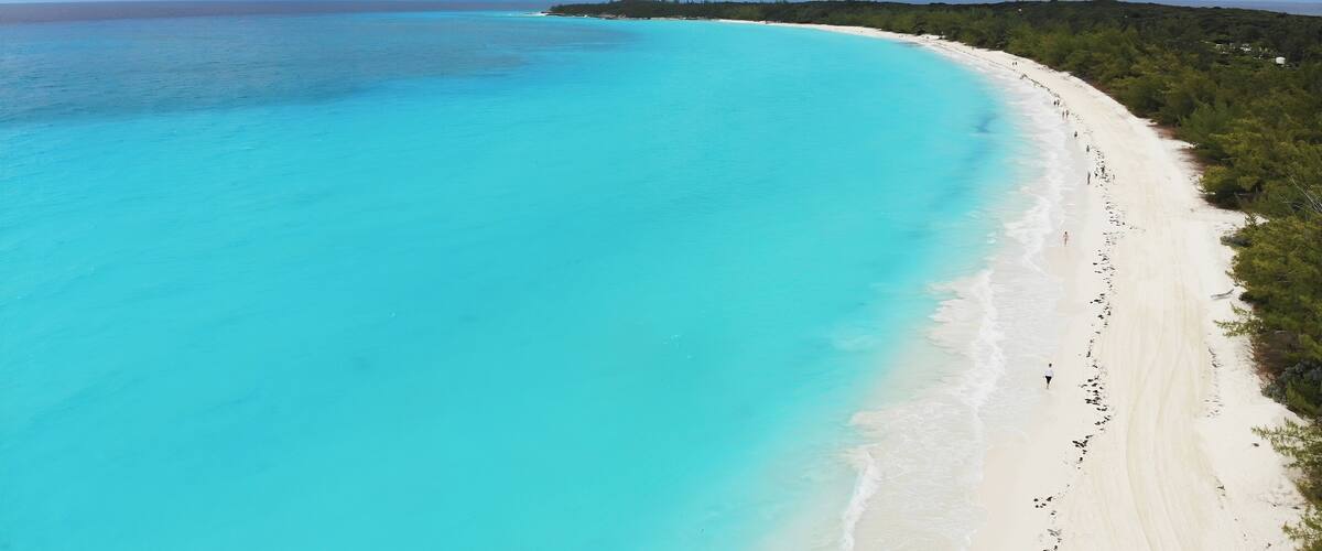 A turquoise beach with white sand and a clear blue ocean.