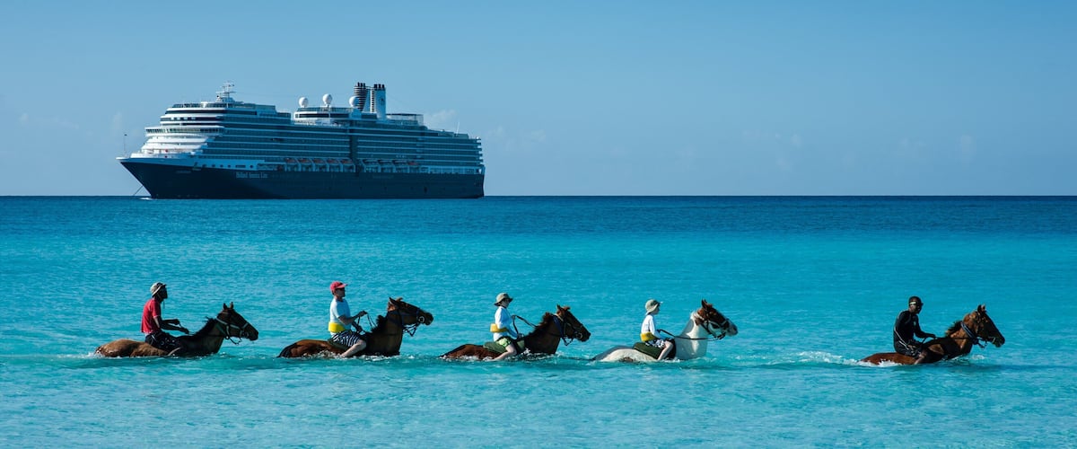A cruise ship in the ocean with people riding horses on the water.