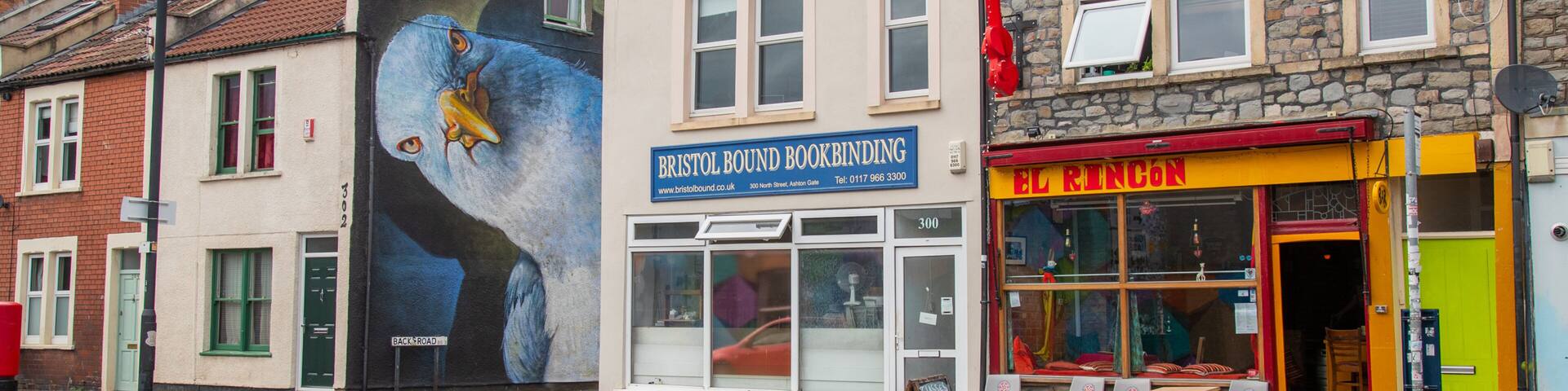 A street with buildings, including a bookbinding shop and a restaurant.