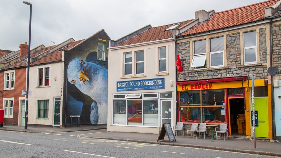 A street with buildings, including a bookbinding shop and a restaurant.