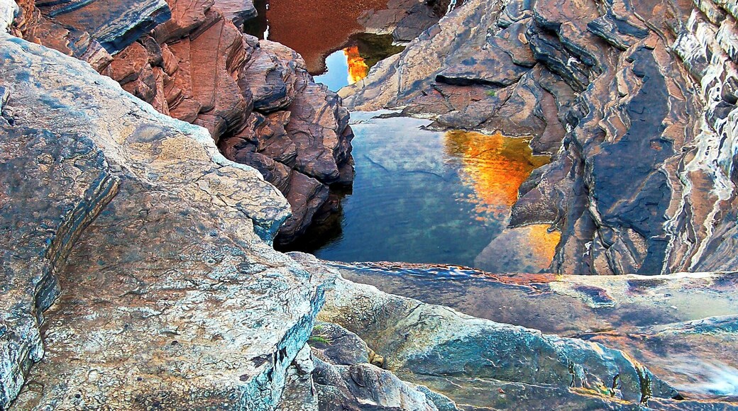 We returned to the motorhome for lunch and moved on to Knox Gorge, some 20 kilometres away. This too was special and I learned that it actually links up with where we were earlier in the day and you can do an 8 hour trek from here and come up the ladder at Hancock Gorge. That would be one heck of a day!
The light wasn’t right at Knox though so we moved around to nearby Joffre Falls where it was better, though it was just on sunset so there wasn’t much time left. The evening hues were the like of which I’d never seen before. Strange ochres beguiled the eye and the reflections of sunset kissed canyon tops in the water below had an air of magic about them. The whole scene was surreal and true all at the same time.
The splashing of the water down the steps of the cascade just added to the allure as I watched it then move through crystalline pools shaded by the erratic cliffs whose ancient layers would dazzle red in the noonday sun.
Everything about it could be explained except the overwhelming feeling that this place was something special and I wouldn’t see its like again.
#Nature