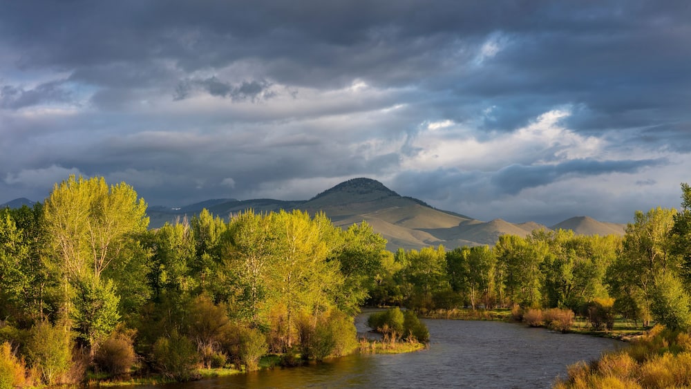 Dramatic stormy sunrise light strikes the Big Hole River near Melrose, Montana, USA