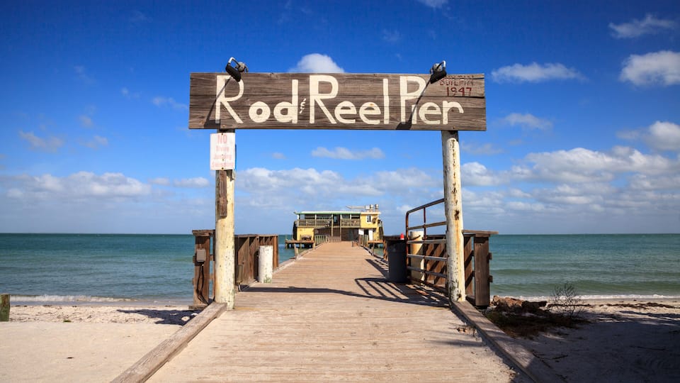 A wooden pier leading to Rod Reeler, a pier with a sign dated 1917.