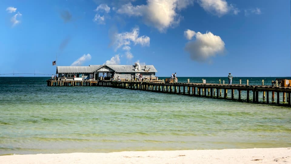 A pier extending into the ocean with a building at the end.