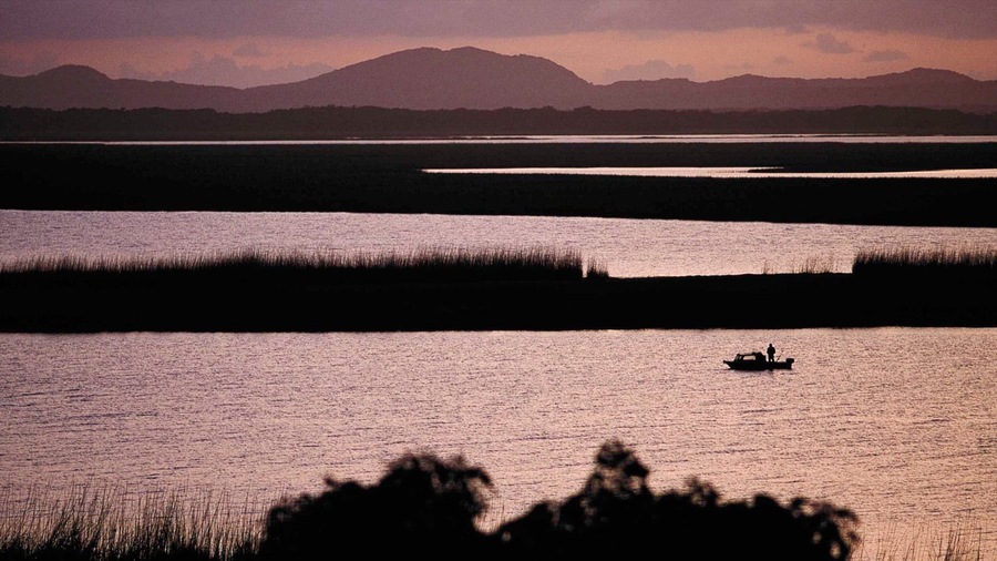 Greater St Lucia Wetland Park which includes a sunset, wetlands and a coastal town