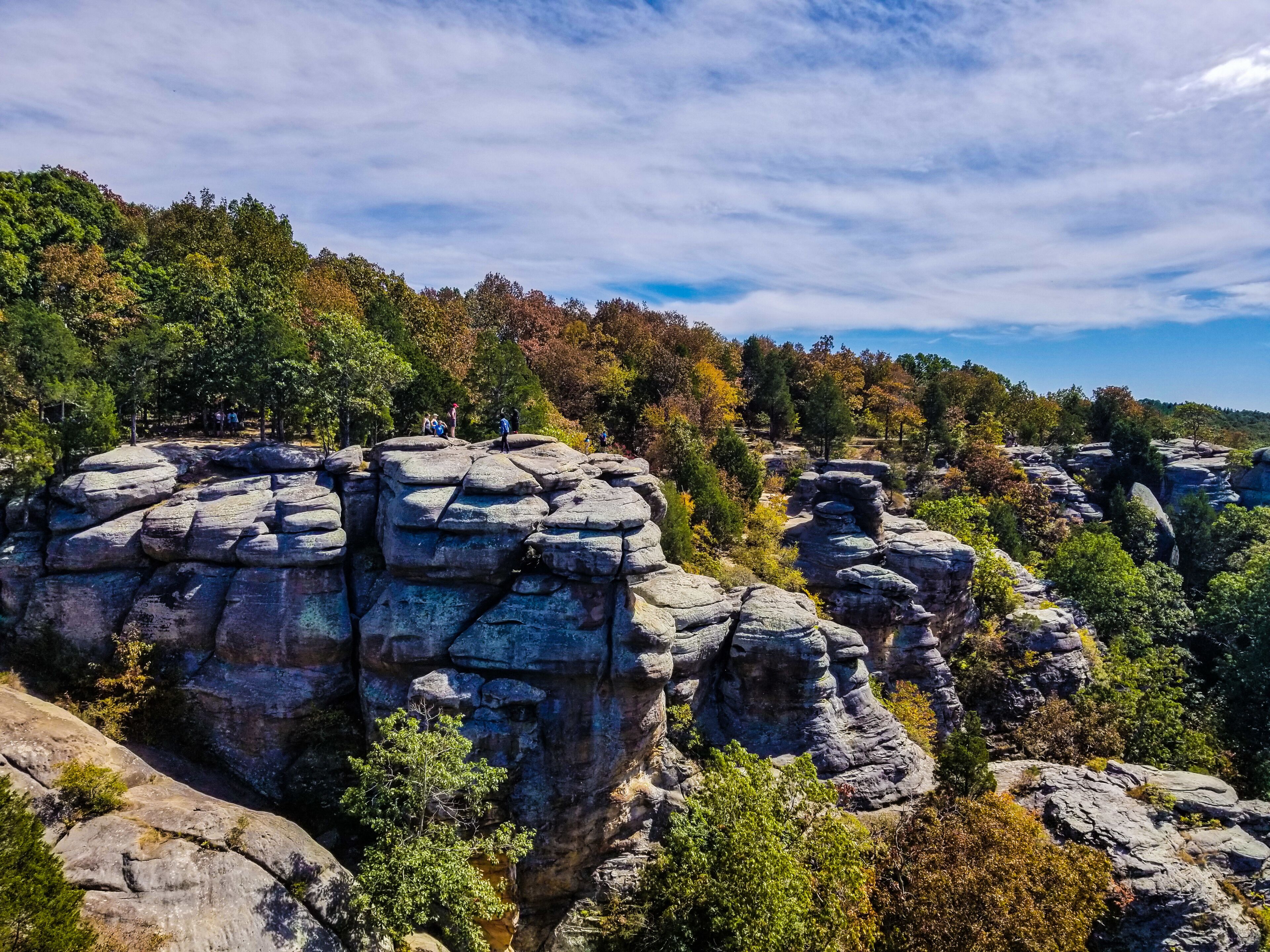 A rocky landscape with people hiking.