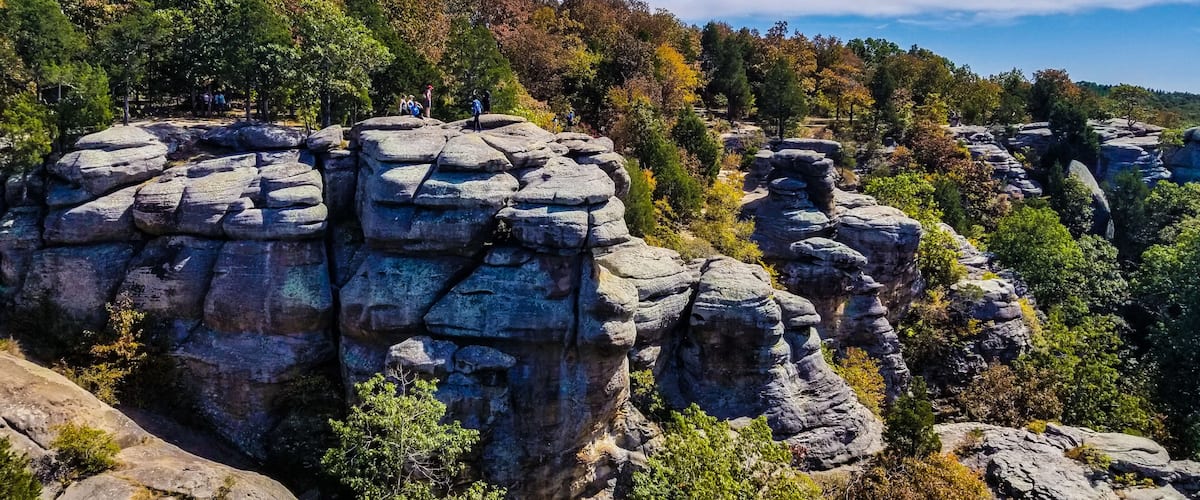 A rocky landscape with people hiking.