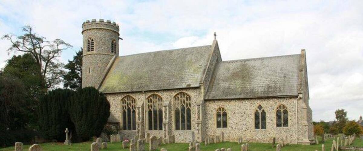 A stone church with a tower and a graveyard.