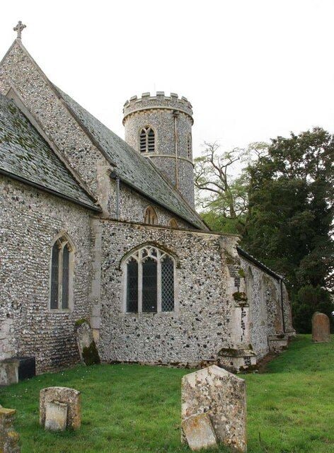 A stone church with a tower and arched windows.