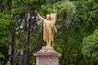 Estatua de Miguel Hidalgo de color oro en el centro del parque La Alameda en la ciudad de Querétaro, México.