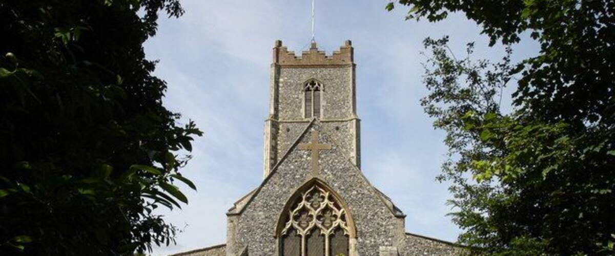 A stone church with a tall tower and arched windows.