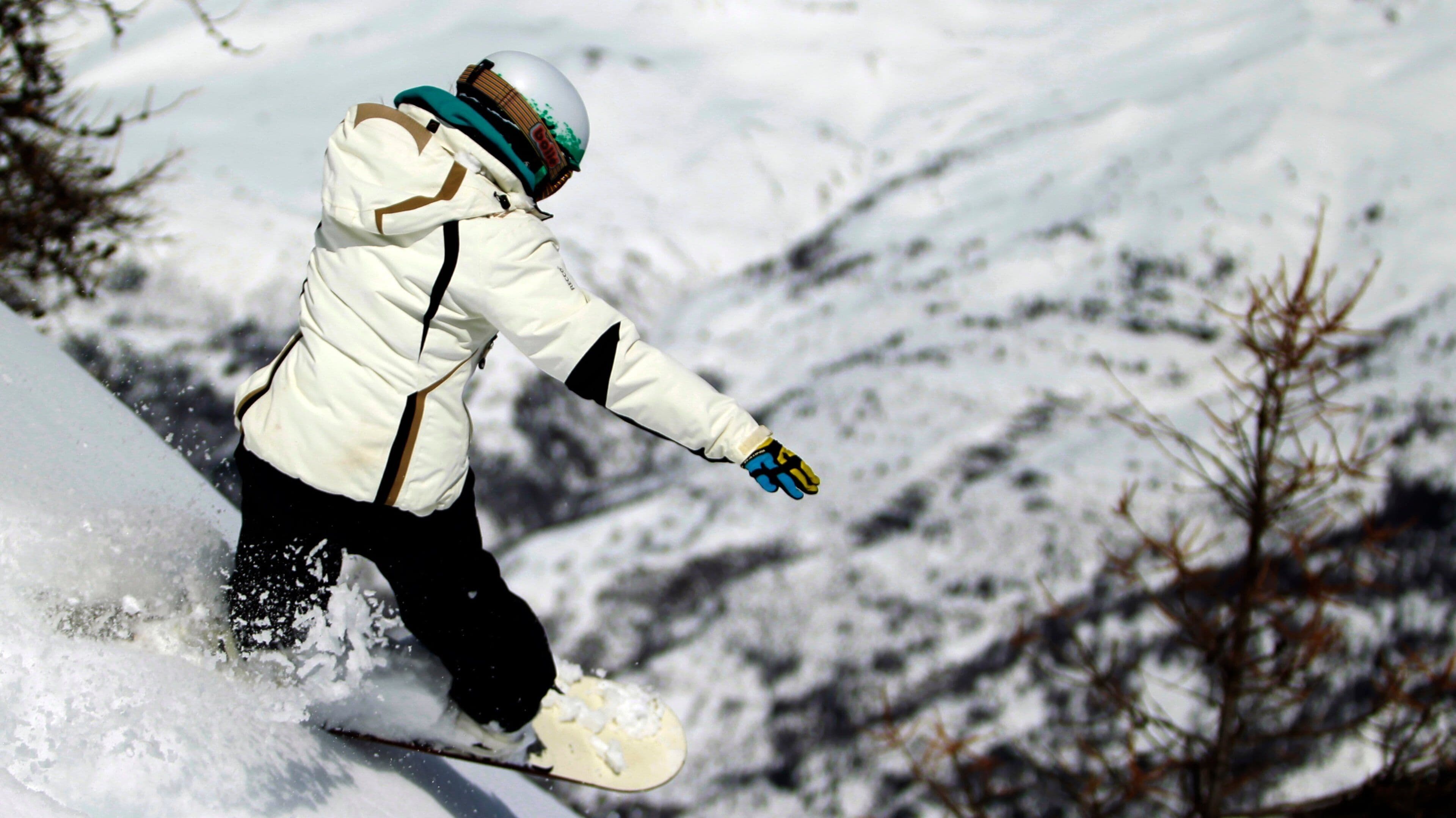 A person snowboarding down a snowy slope.