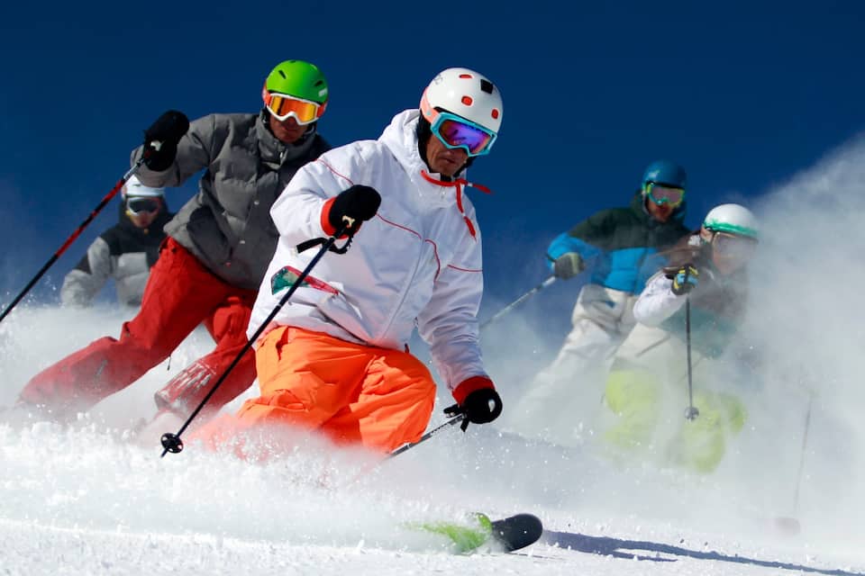 Skiërs scheeren over een besneeuwde helling.