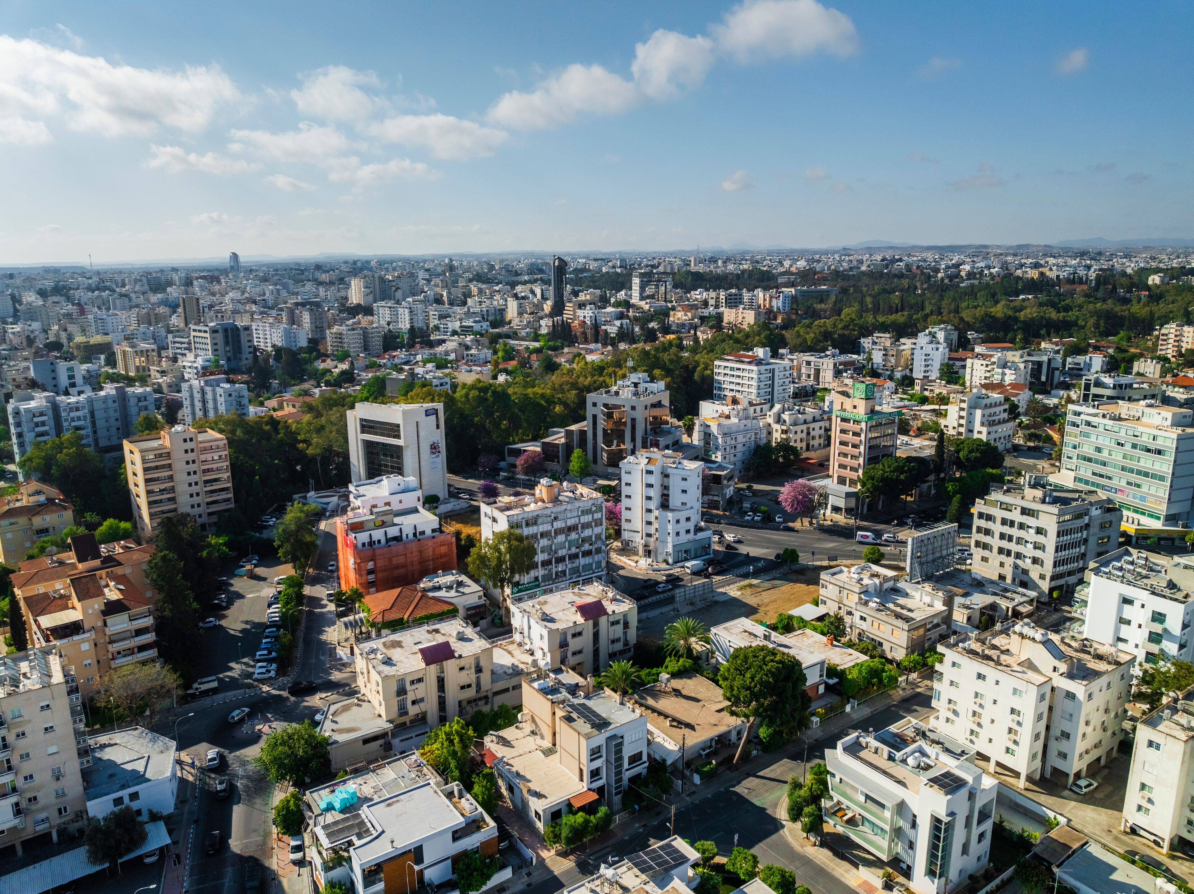 Aerial view of vibrant urban skyline with modern high-rise buildings and greenery, Egkomi Lefkosias, Nicosia, Cyprus.