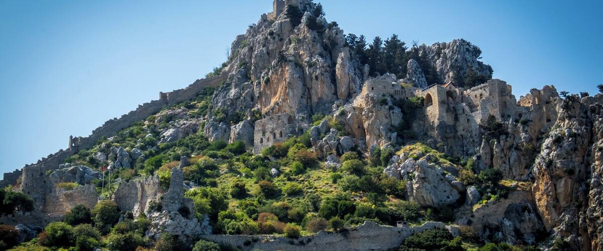 A rugged mountain with ancient ruins and dense greenery.