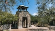 Un centre d’accueil pour les visiteurs, construit en pierre et doté d’un toit végétalisé, entouré d’arbres et de plantes du désert.
