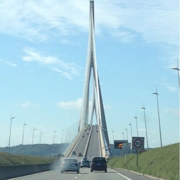 A bridge with tall towers and a road with cars.