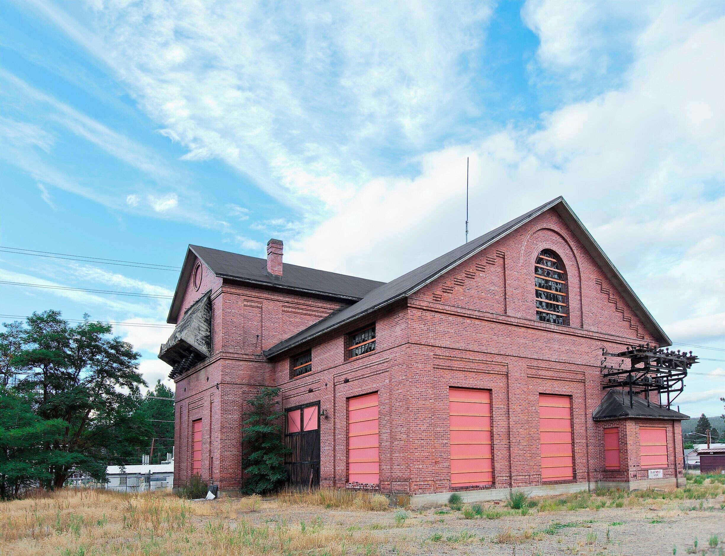 A red brick building with a gabled roof and large windows.