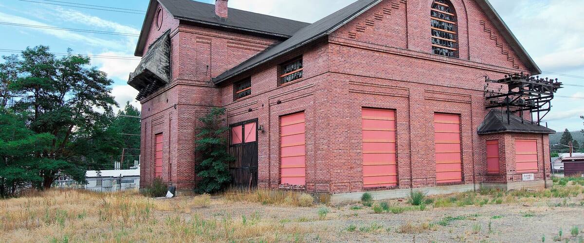 A red brick building with a gabled roof and large windows.
