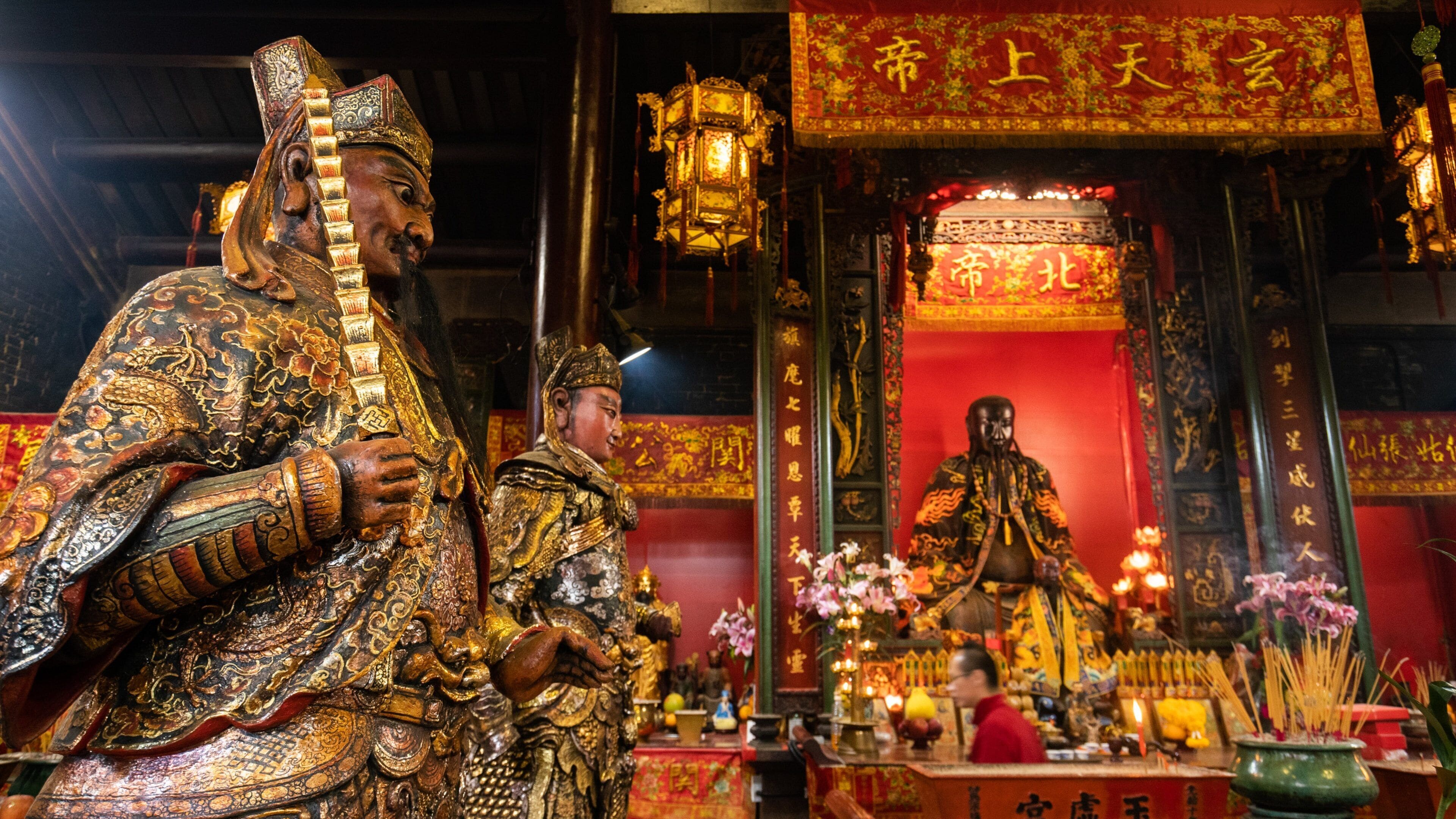 A temple interior with ornate statues and traditional Chinese decorations.
