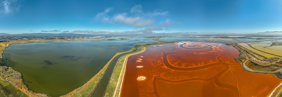 Aerial panorama view of Alviso district in San Jose California with rundown buildings colorful orange, yellow salt marshes in the Bay Area