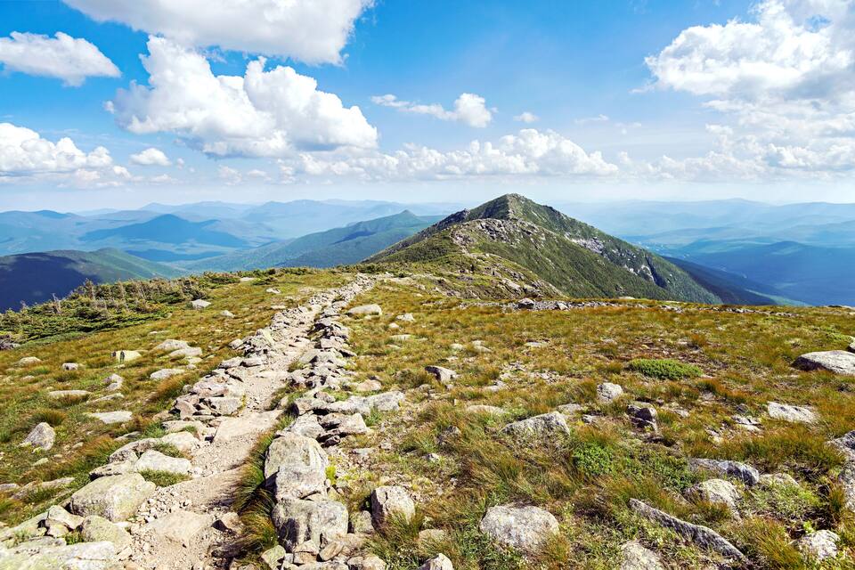 A mountain trail with rocky terrain and a clear sky.