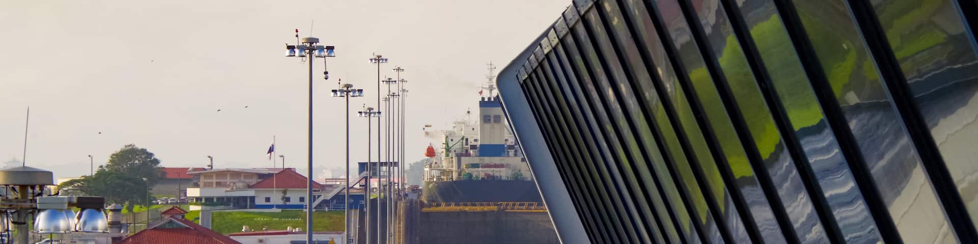 Almost no space between modern cruiseship or cruise ship liner and concrete walls of Panama Canal inside locks