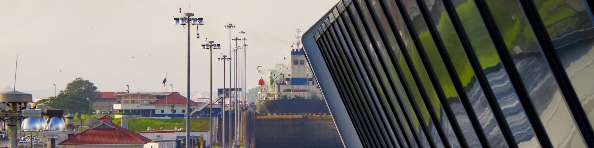 Almost no space between modern cruiseship or cruise ship liner and concrete walls of Panama Canal inside locks