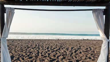 Sunrise on empty volcanic sand beach - View of the sea from a cabin in Port of San Jose in Guatemala, Central America