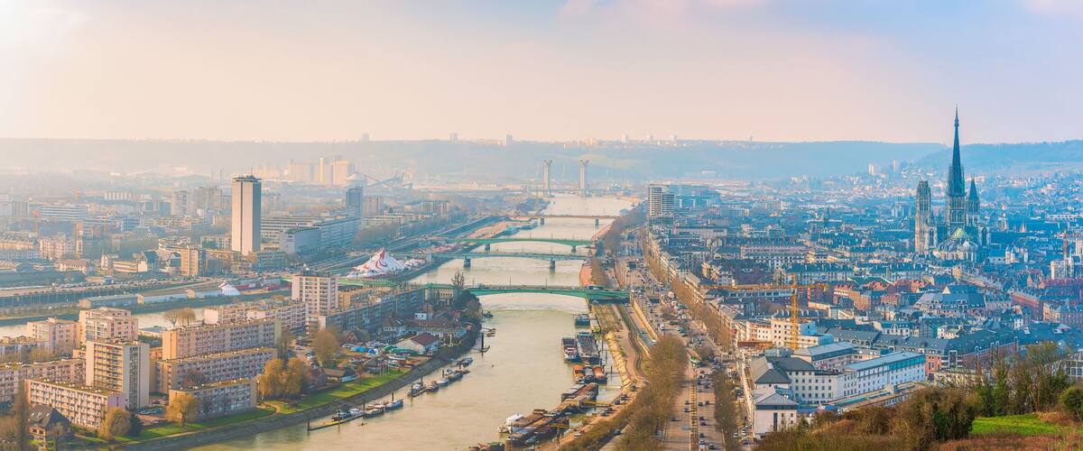 A cityscape with a river, bridges, and a prominent tower.