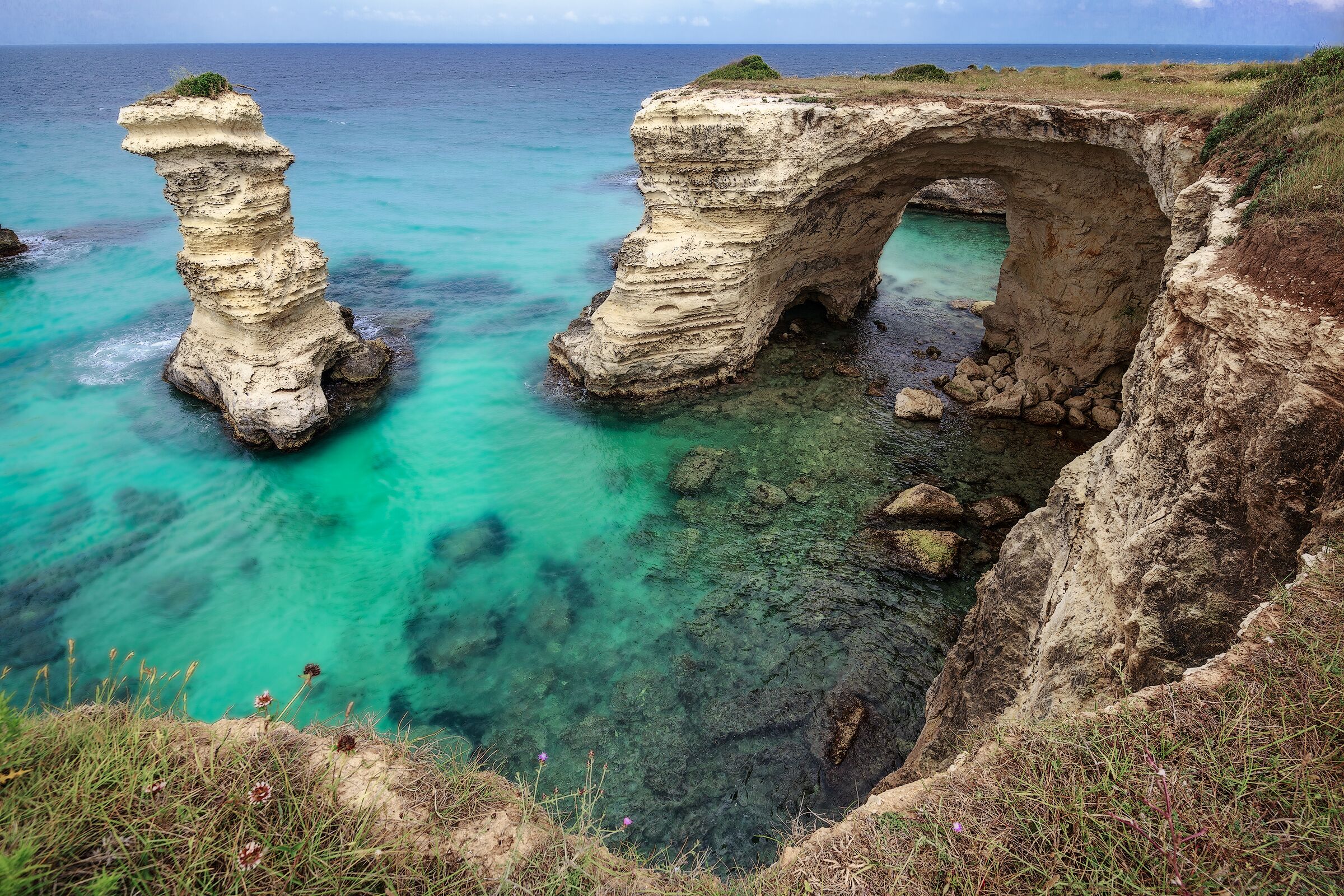 Torre Sant'Andrea is a small town on the Adriatic coast of Salento. It 'a very small and ancient fishing village that is located where the coast is slightly higher.
The extraordinary nature of its coast and its sea, make it an unforgettable destination. The coastline is, in fact, remained almost untouched and looks ragged, full of ravines and caves, the protrusions and recesses and large isolated rocks in the sea, real stacks.
What amazes the eye is the presence of these magnificent rocks rising from crystal clear that water ... The sea erosion has created in this place something truly magical. High cliffs stand not far from the coast and look like giant guarding the territory.
The most beautiful cliff is shaped like a arch: swim under this rock is a unique experience that can only be done in some corners of the world.
If you're ever in the right day, you will find calm and crystalline water that will never forget. The color of the sea, in fact, goes from light green to emerald green, revealing an extraordinary backdrop.