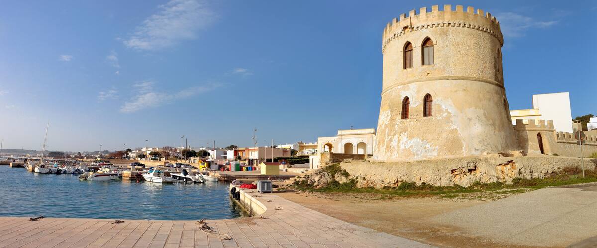 A coastal town with a historic tower by the harbor.