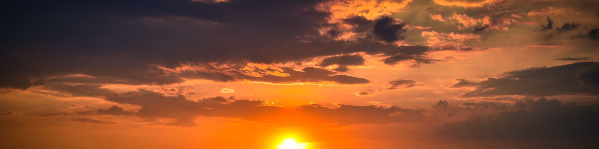 Un atardecer sobre el horizonte de una ciudad con edificios destacados y nubes.
