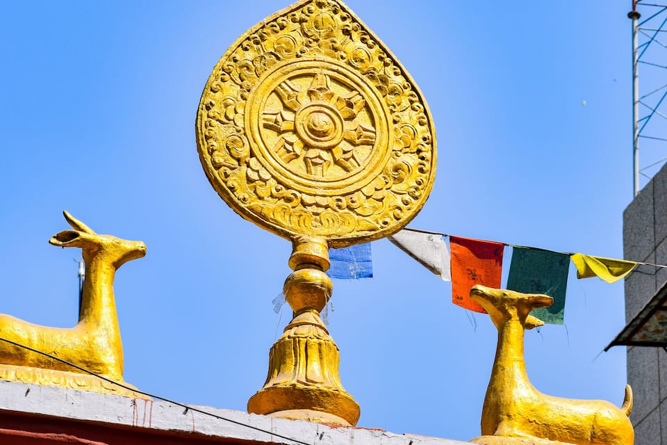 A golden emblem with intricate designs on a building's facade, flanked by two golden animal statues.