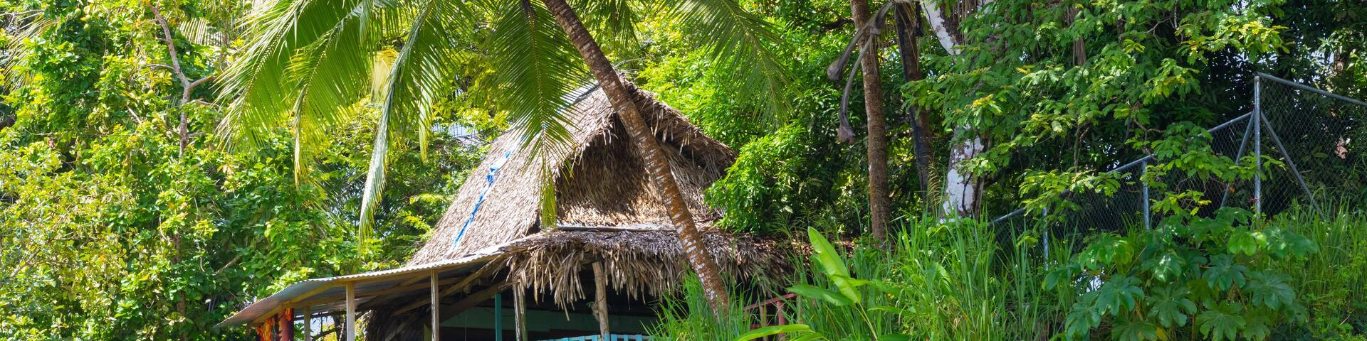 Panama, Chiriqui province, Limones welcome sign made from tree trunks, and jungle hut