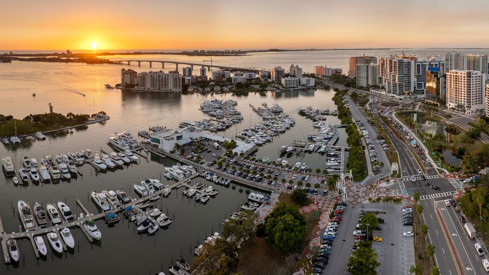 Aerial view of Sarasota city downtown at sunset with bay marina yachts and high-rise office buildings. Real estate development in Florida. USA travel destination