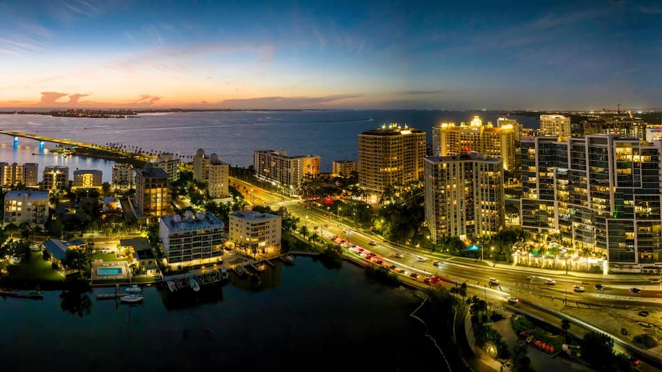 Sarasota aerial blue hour with city and Ringling bridge lit up.