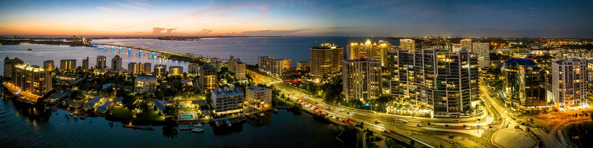 Sarasota aerial blue hour with city and Ringling bridge lit up.