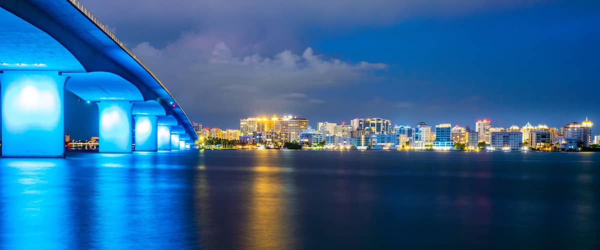 Sarasota Florida city lights at dusk with the Ringling Bridge lit up blue.