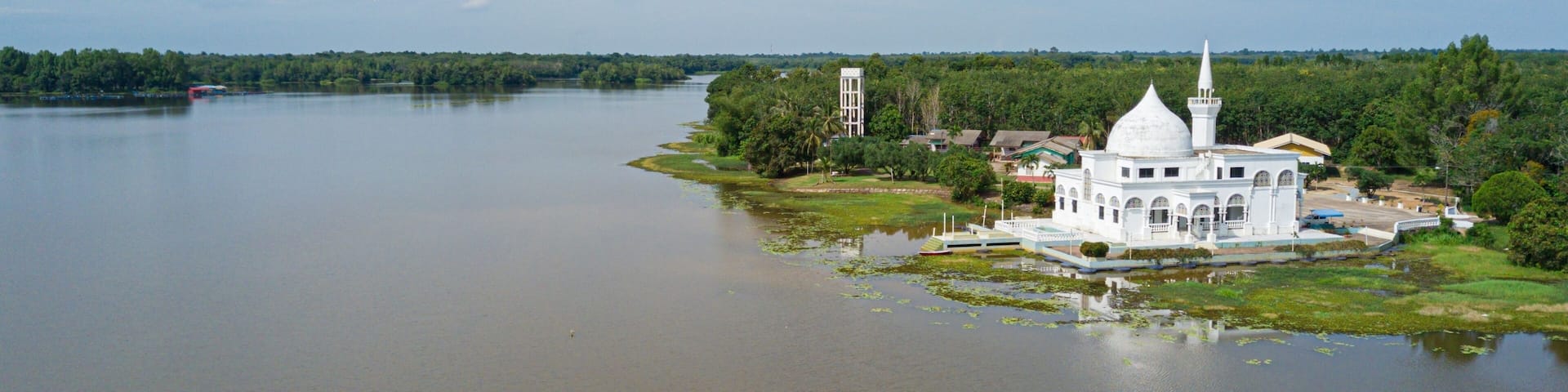 Drone shot of a white mosque by a lake at Danau Tok Uban, Tanah Merah, Kelantan, Malaysia.
