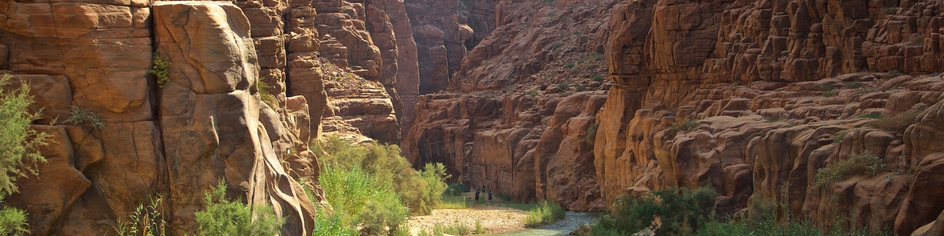 Mujib Nature Reserve featuring a river or creek and a gorge or canyon as well as a small group of people