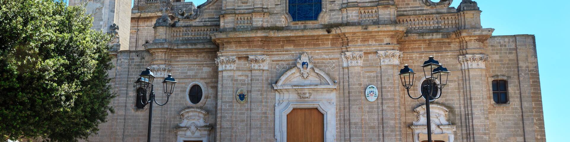 A historic church with ornate architecture, including a bell tower and a large wooden door.