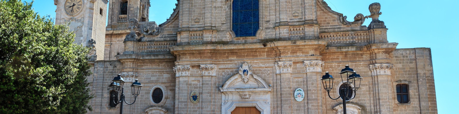 Une église historique à l’architecture riche et élaborée, comprenant un clocher et une grande porte en bois.