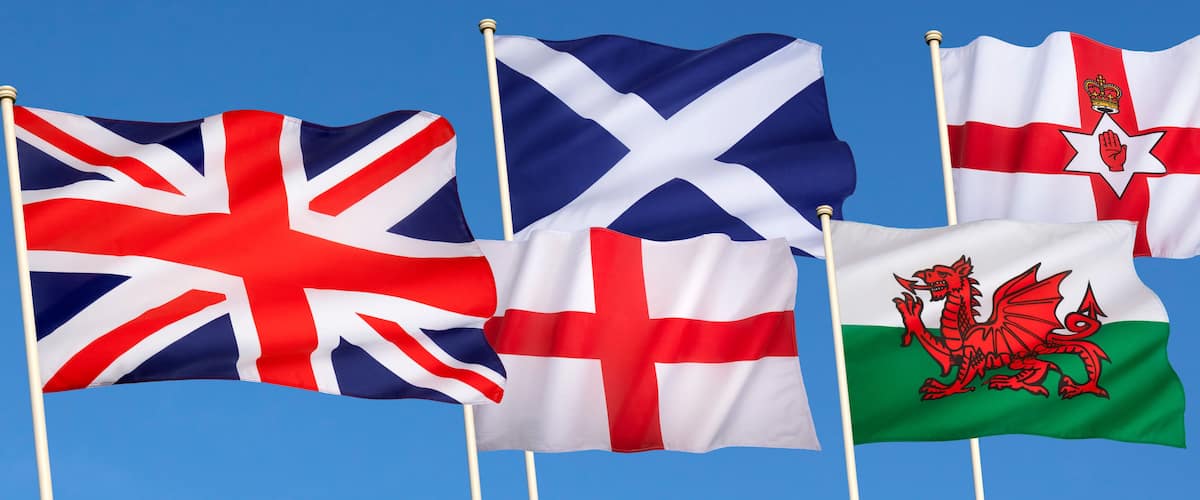 Five flags waving against a clear blue sky.