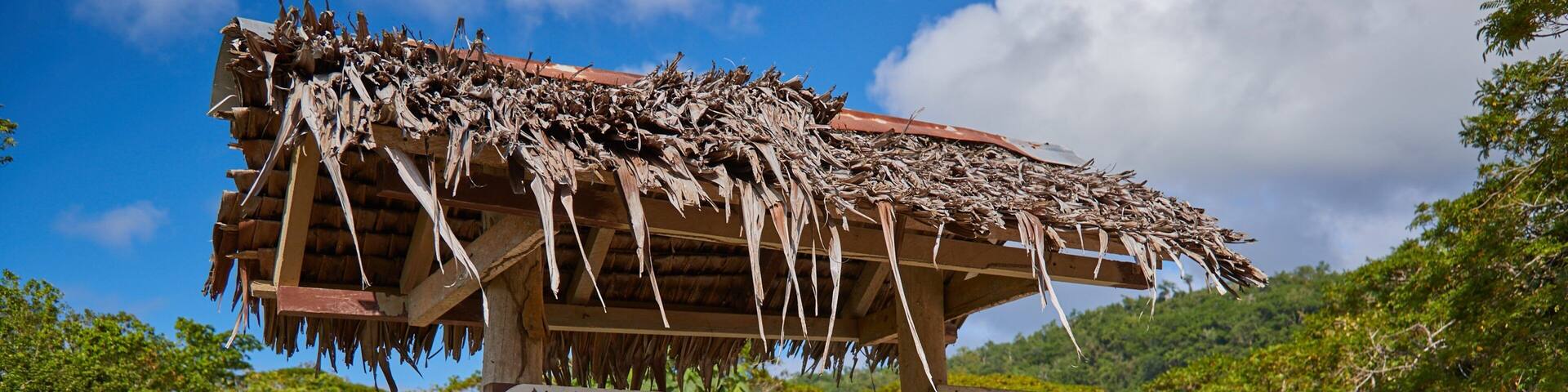 A wooden sign with a thatched roof, welcoming visitors to Loma Beach Bungalows, featuring a restaurant/bar.