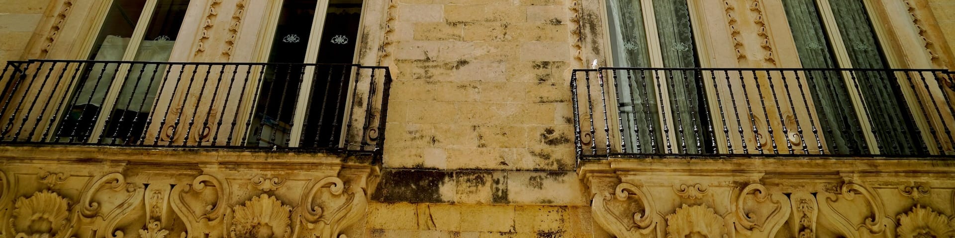 A historic building with ornate balconies and detailed carvings.